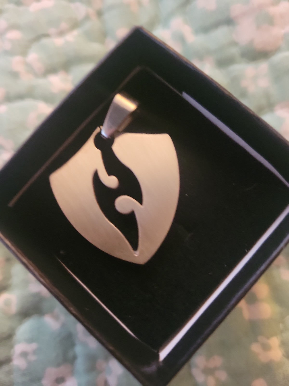 Shield pendant with flame cutout
