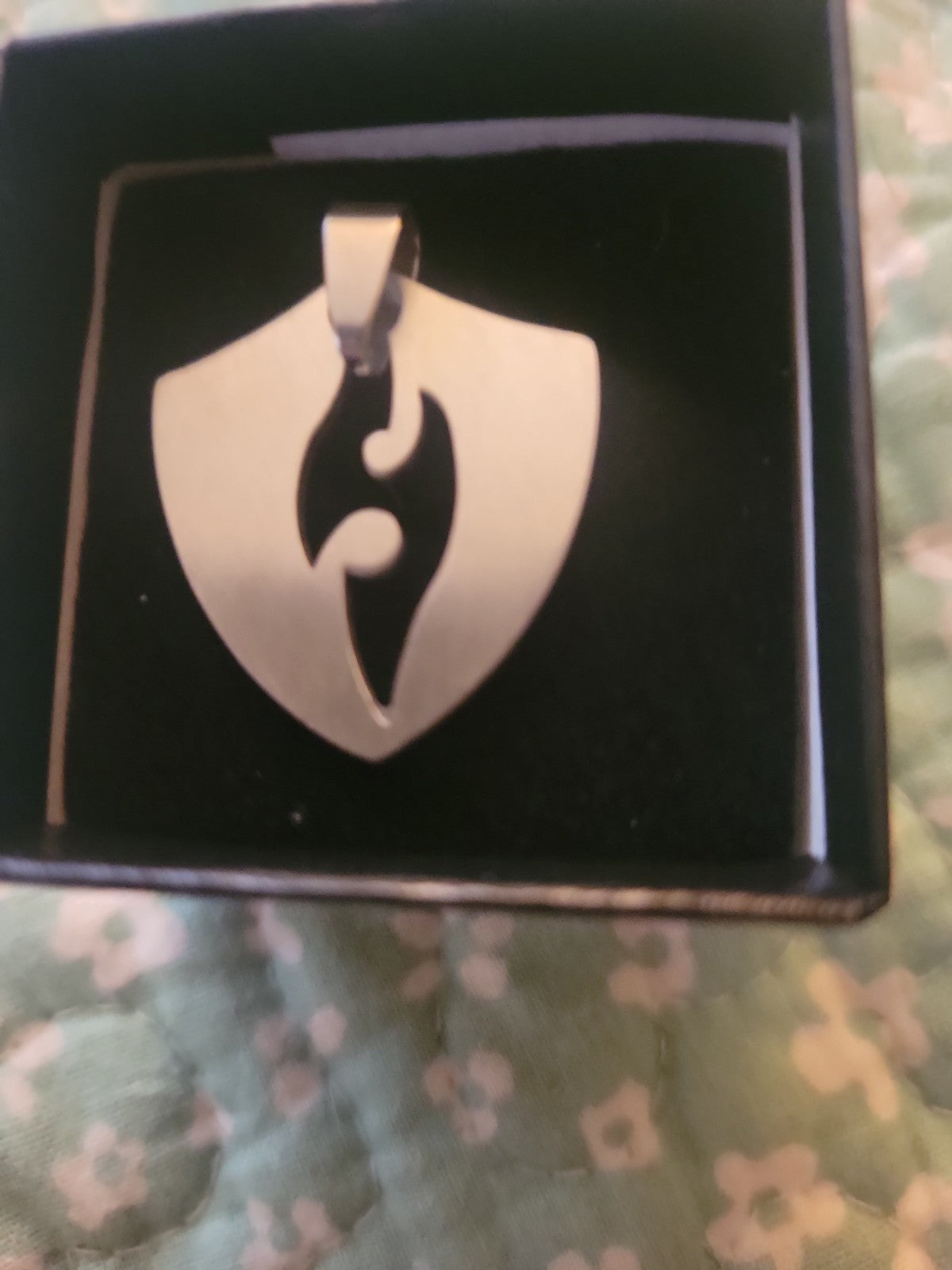Shield pendant with flame cutout