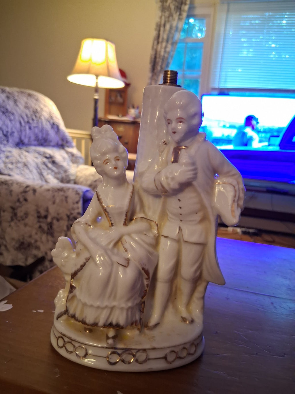 Porcelain figurine depicting a Victorian courting couple in white with gold...