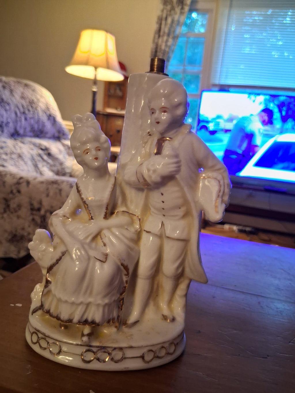 Porcelain figurine depicting a Victorian courting couple in white with gold...