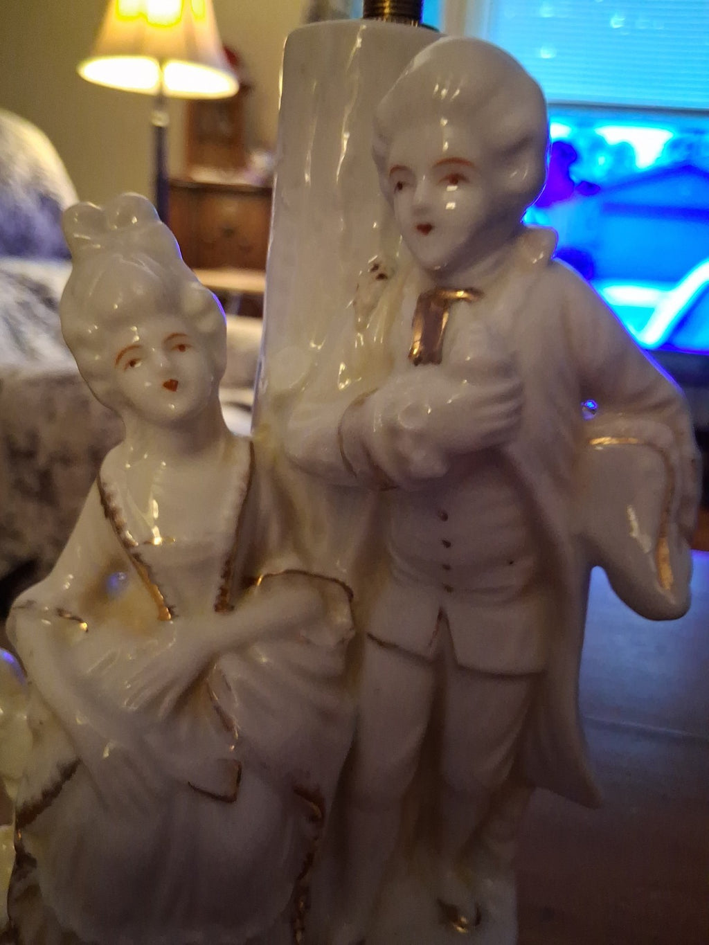 Porcelain figurine depicting a Victorian courting couple in white with gold...