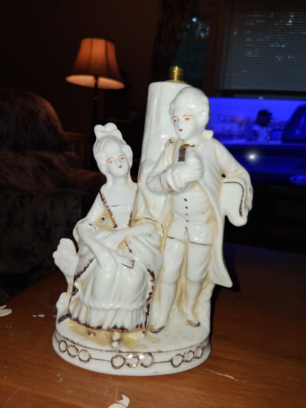 Porcelain figurine depicting a Victorian courting couple in white with gold...
