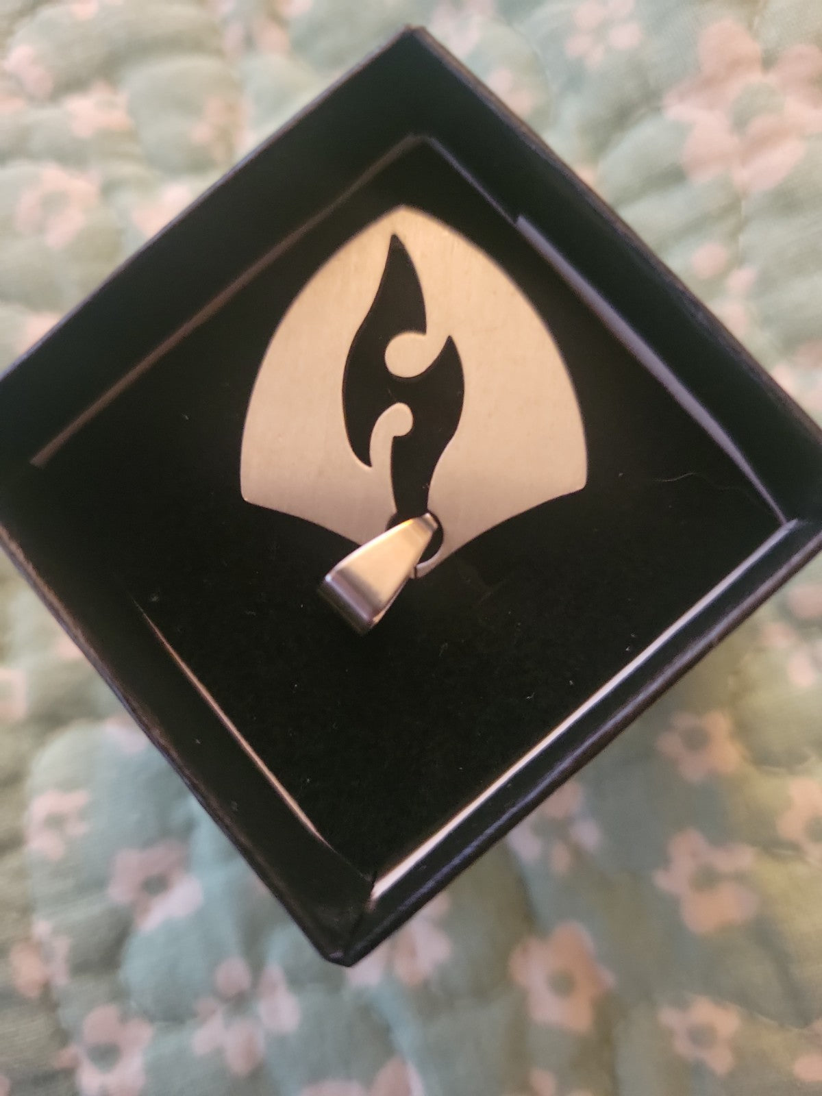 Shield pendant with flame cutout