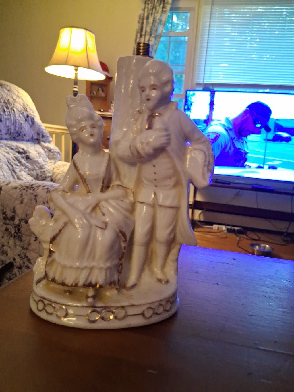 Porcelain figurine depicting a Victorian courting couple in white with gold...